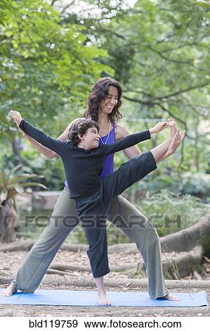 Stock Photo - Hispanic mother and son practicing yoga. Fotosearch
