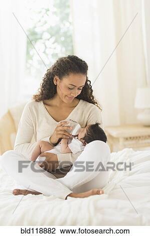 Hispanic mother bottle feeding infant son View Large Photo Image Stock Image - Hispanic mother bottle feeding infant son. Fotosearch