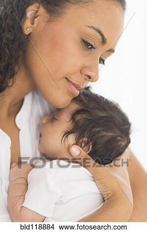 Picture - Hispanic mother holding infant son. Fotosearch