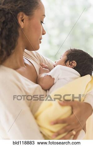 Stock Image - Hispanic mother holding infant son. Fotosearch