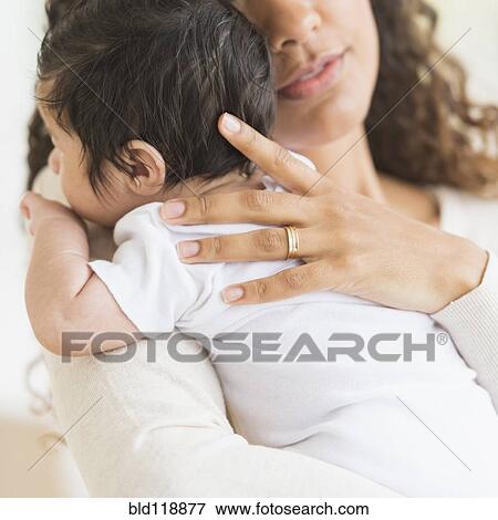 Stock Photo - Hispanic mother holding infant son. Fotosearch