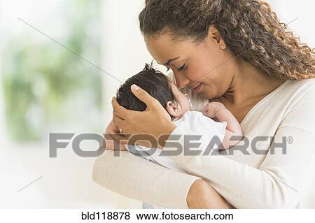 Stock Photo - Hispanic mother holding infant son. Fotosearch