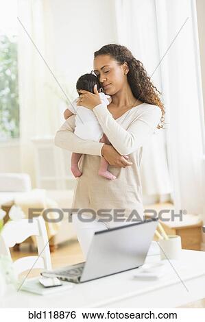 Stock Photograph - Hispanic mother holding infant son. Fotosearch