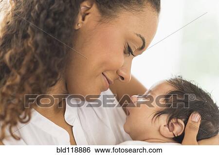 Stock Photograph - Hispanic mother holding infant son. Fotosearch