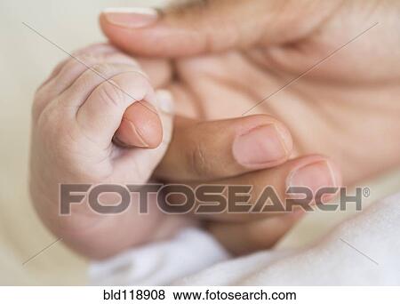 Stock Photo - Hispanic mother holding infant's hand. Fotosearch