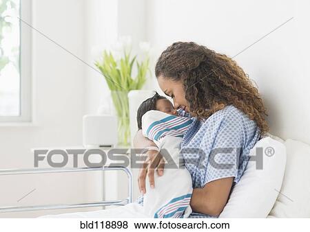 Hispanic mother holding newborn in hospital View Large Photo Image Stock Photo - Hispanic mother holding newborn in hospital. Fotosearch