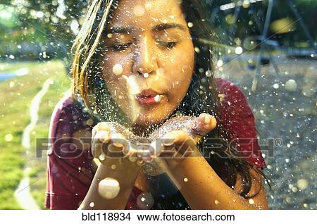 Picture - Hispanic teenage girl playing with glitter outdoors. Fotosearch