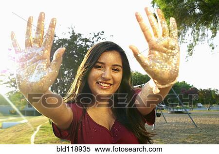 Hispanic teenage girl playing with glitter outdoors View Large Photo Image Stock Photography - Hispanic teenage girl playing with glitter outdoors. Fotosearch