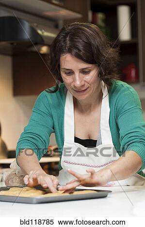 Stock Photography - Hispanic woman baking in kitchen. Fotosearch