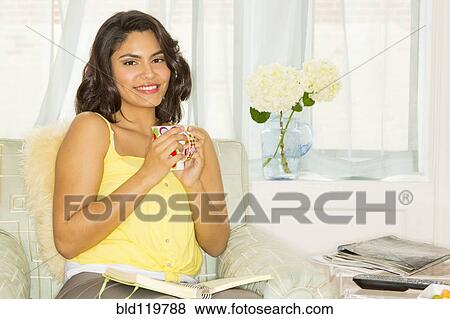 Stock Photo - Hispanic woman enjoying cup of coffee. Fotosearch