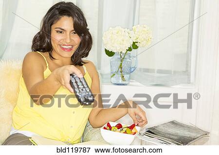 Hispanic woman holding remote control View Large Photo Image Stock Photo - Hispanic woman holding remote control. Fotosearch