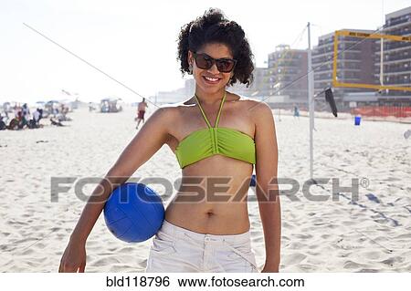 Hispanic woman holding volleyball on beach View Large Photo Image Stock Photograph - Hispanic woman holding volleyball on beach. Fotosearch