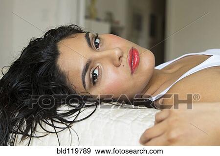 Hispanic woman laying on bed View Large Photo Image Stock Photo - Hispanic woman laying on bed. Fotosearch
