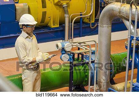 Hispanic worker checking machinery View Large Photo Image Picture - Hispanic worker checking machinery. Fotosearch