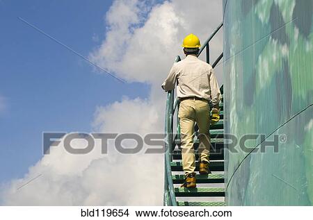 Hispanic worker climbing water tower View Large Photo Image Picture - Hispanic worker climbing water tower. Fotosearch