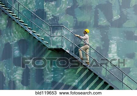 Hispanic worker climbing water tower View Large Photo Image Stock Image - Hispanic worker climbing water tower. Fotosearch