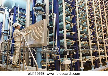 Stock Photo - Hispanic worker using machinery. Fotosearch