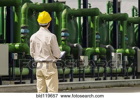Stock Photo - Hispanic worker wearing hard hat outdoors. Fotosearch
