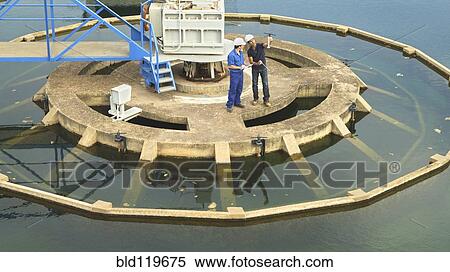 Stock Photography - Hispanic workers checking water quality. Fotosearch