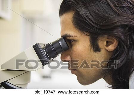 Stock Photo - Indian scientist using microscope in laboratory. Fotosearch