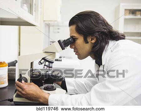 Stock Photograph - Indian scientist using microscope in laboratory. Fotosearch