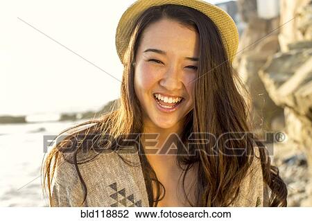 Stock Image - Japanese woman smiling on beach. Fotosearch