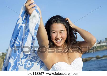 Stock Photo - Japanese woman smiling on beach. Fotosearch