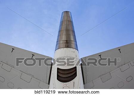 Stock Photo - Low angle view of airplane tail against blue sky. Fotosearch