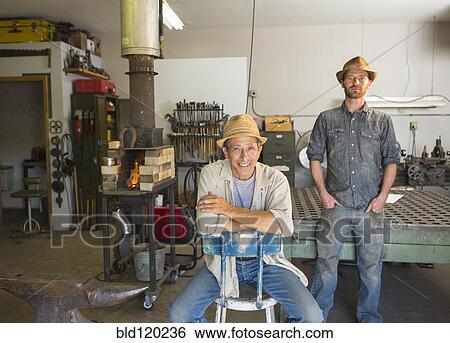Stock Photograph - Men smiling in workshop. Fotosearch