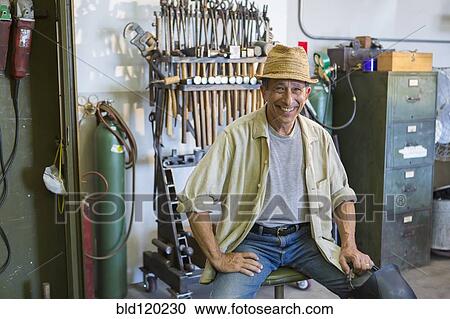Stock Image - Middle Eastern man smiling in workshop. Fotosearch