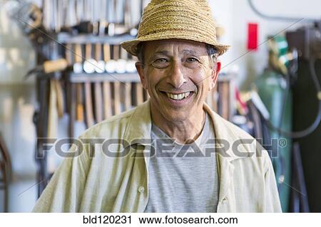 Stock Image - Middle Eastern man smiling in workshop. Fotosearch