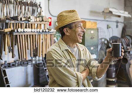 Middle Eastern man smiling in workshop View Large Photo Image Stock Image - Middle Eastern man smiling in workshop. Fotosearch
