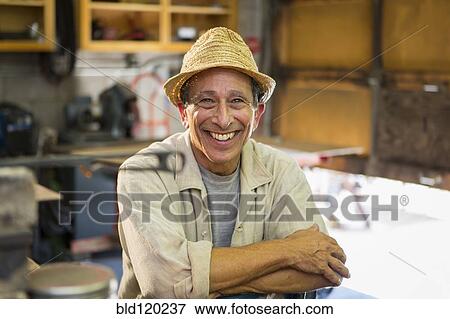 Stock Photo - Middle Eastern man smiling in workshop. Fotosearch
