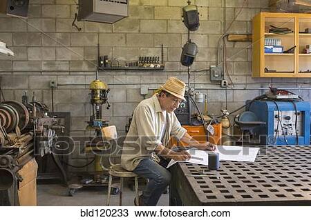Stock Image - Middle Eastern man working in workshop. Fotosearch