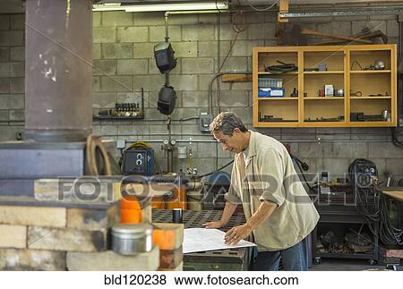 Stock Photo - Middle Eastern man working in workshop. Fotosearch