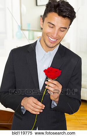 Stock Photography - Mixed race businessman holding rose. Fotosearch