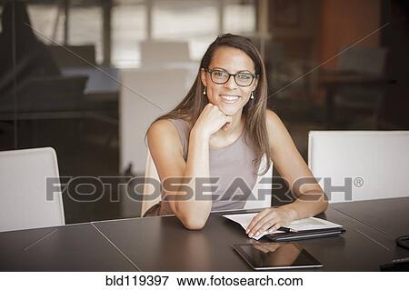 Stock Photo - Mixed race businesswoman smiling at desk. Fotosearch