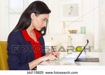 Stock Photo - Mixed race businesswoman working at desk. Fotosearch