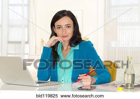 Stock Photography - Mixed race businesswoman working at desk. Fotosearch