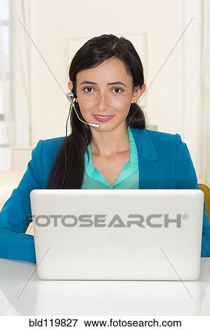 Stock Photo - Mixed race businesswoman working at laptop. Fotosearch