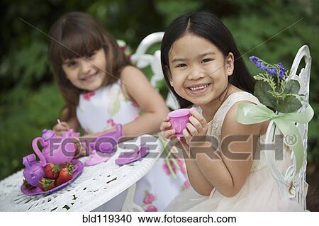 Mixed race girls having tea party in backyard View Large Photo Image Stock Image - Mixed race girls having tea party in backyard. Fotosearch
