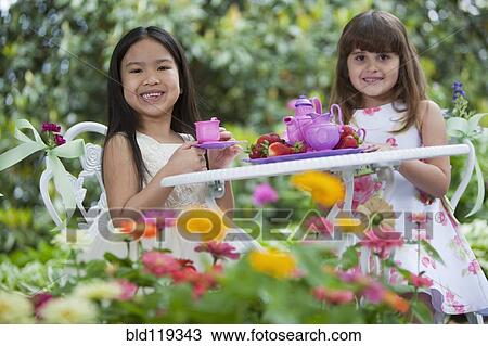 Mixed race girls having tea party in backyard View Large Photo Image Stock Image - Mixed race girls having tea party in backyard. Fotosearch