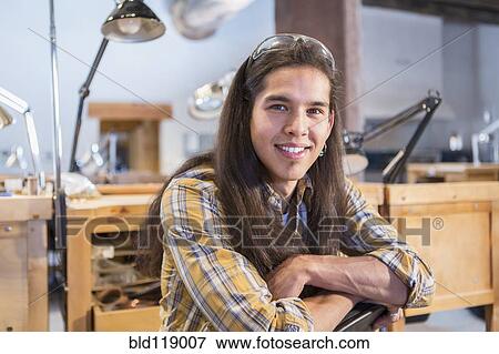 Stock Photo - Mixed race man smiling in art studio. Fotosearch
