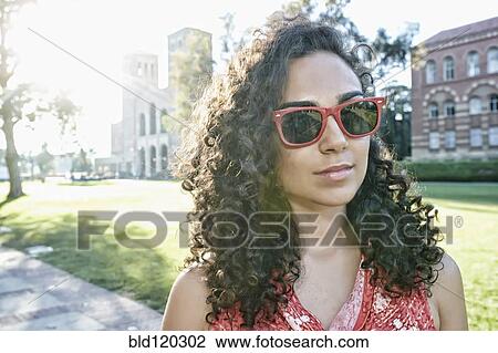 Stock Image - Mixed race student walking on campus. Fotosearch