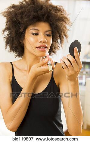 Stock Photo - Mixed race woman applying makeup. Fotosearch