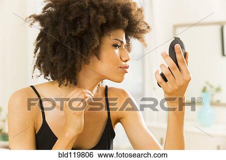 Mixed race woman checking her makeup View Large Photo Image Stock Photograph - Mixed race woman checking her makeup. Fotosearch