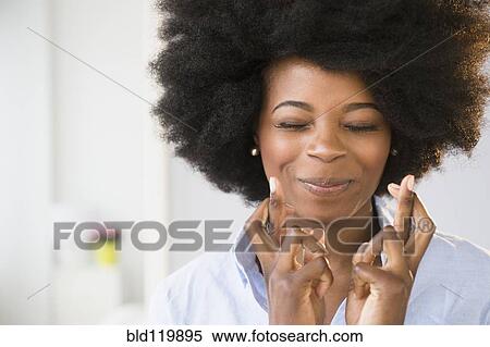 Stock Photography - Mixed race woman crossing her fingers. Fotosearch