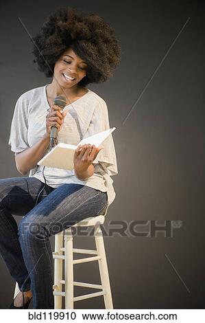 Mixed race woman doing poetry reading on stage View Large Photo Image Stock Image - Mixed race woman doing poetry reading on stage. Fotosearch