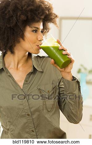 Mixed race woman drinking green smoothie View Large Photo Image Stock Image - Mixed race woman drinking green smoothie. Fotosearch
