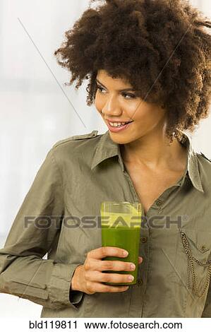 Mixed race woman drinking green smoothie View Large Photo Image Stock Image - Mixed race woman drinking green smoothie. Fotosearch